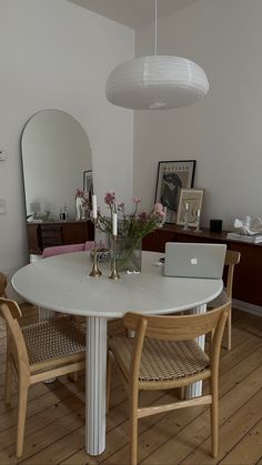 a white table with two chairs and a laptop on top of it in a room