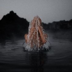 a woman is floating in the water with her head above the water's surface