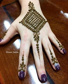 a woman's hand with henna tattoos on it