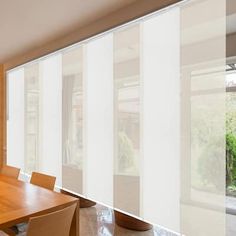 a dining room table and chairs with sliding glass doors on the wall in front of them