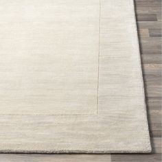 a white rug on top of a wooden floor