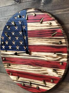 an american flag clock made out of wooden planks on a wood wall with metal studs