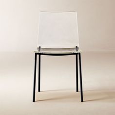 a white chair sitting on top of a wooden table next to a black metal frame