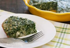 a piece of spinach pie on a white plate with a fork next to it