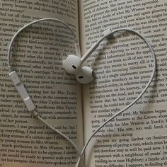 an open book with headphones in the shape of a heart