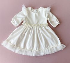 Baptism dress for baby girl with pearls. The colour of this dress is ivory.  There are tulle ruffles on the shoulders and pearl belt on the waist. Fabric-natural cotton.  The price is only for the dress.  We can sew matching booties, bloomers, headband with the same lace as on the dress. headband: https://www.etsy.com/listing/1277763367/pearl-headband-baby-girl-flower-girl?click_key=9393e6bb703f386c0c50cd01bd709eaa8bb3fb9f%3A1277763367&click_sum=d890857f&ref=shop_home_active_23&frs=1&sts=1 Booties: https://www.etsy.com/listing/1289288259/booties-with-pearls-for-baby-girl?click_key=113a40180a248241c7aecfc9d3b7cb88de5f260b%3A1289288259&click_sum=44c05677&ref=shop_home_active_1&frs=1&sts=1 bloomers: https://www.etsy.com/listing/1289301209/baptism-bloomers-baby-girl-bloomers?click_key=1b9d14d9 Toddler Baptism, Girl Baptism Dress, Christening Dress Baby Girl, Girls Baptism Dress, Baptism Dress Baby Girl, Dress For Baby Girl, Pearl Belt, Tulle Ruffles