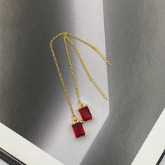 These Ruby Red Teardrop Crystal Thread Earrings are a dazzling combination of elegance and simplicity. Featuring striking ruby red teardrop crystals delicately suspended from slender chains, they provide an eye-catching pop of color and a subtle sparkle. Perfect for any occasion, they effortlessly enhance both casual and formal looks with their timeless appeal. Measurements: The total length from the top of the hook to bottom - 3.74 inches (95 mm) approximately. Crystals: 8 mm x 5 mm These earri Elegant Red Drop Earrings, Minimalist Red Jewelry For Party, Minimalist Red Party Jewelry, Elegant Red Drop Crystal Earrings, Elegant Red Crystal Earrings, Elegant Red Earrings With Ear Wire, Red Minimalist Dangle Earrings, Crystal Earrings Wedding, Red Thread