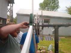 a man standing next to a wind turbine