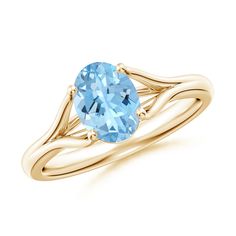 a yellow gold ring with an oval blue topazte stone in the center and two twisted bands around it