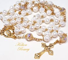 White Faceted Pearl Catholic Rosary. Features Swarovski AB crystal beads  Luminous white, 6mm faceted crystal pearls make up the Ave beads. Each crystal pearl starts with a crystal base, and has thick layers of real pearl nacre coating. Pearls have an elegant look, and a lustrous shimmer.  The Pater beads are 6x8mm Swarovski AB crystals, with large facets that catch and reflect the light at every angle. Beads are capped with filigree gold bead caps for an elegant touch. The ornate grapes and vin Elegant Pearl Rosary With 8mm Beads, Elegant Pearl White Pearl Rosary, Elegant White Pearl Rosary, Elegant Pearl Rosary With Round Beads, Elegant White Rosary With Round Beads, Elegant Pearl Beaded Rosary, Elegant Pearl White Rosary With Round Beads, Faceted Pearl, Gold Rosary