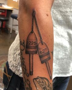 a person with a tattoo on their arm holding a piece of pizza and two buoys