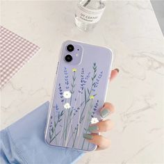 a woman's hand holding an iphone case with flowers painted on the front and sides