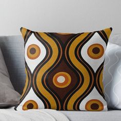 an orange, brown and white abstract design on a couch throw pillow with decorative circles in the center