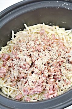 the food in the slow cooker is covered with cheese and ham