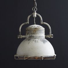 an old white light hanging from a chain