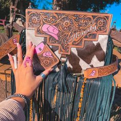 Y’all Requested A Cowhide Version Of The Howdy Purse, And I Am So Excited To Deliver! She Features A Cowhide Body, Leather Back, A Painted Tooled Leather Piece, A Zipper Top, A Tooled Matching Strap, And A Option Card Holder. Dimensions Are Approximately 11 3/4” X 9” The Interior Contains One Zippered Pocket Please Note Each Purse Will Be Made With A Brand New Unique Cowhide Piece. All Tooled Pieces Are Done By Hand And Hand Painted So Each Piece Will Reflect That By Having Slight Imperfections. Western Bags Purses, Leather Fringe Purse, Western Bag, Ace Card, Cowhide Purse, Western Purses, Western Accessories, Cow Boy, Leather Pieces