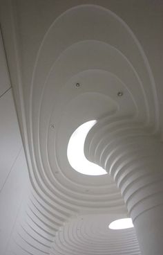 the inside of a building with white walls and circular lights on each side of the ceiling