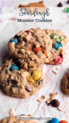 three cookies with m & m on top and the words sourdough monster cookies