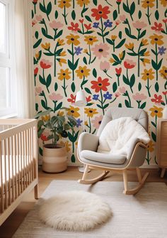 a baby's room with a floral wallpaper and rocking chair