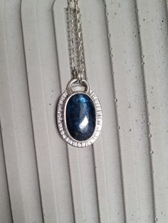 This kyanite necklace in sterling silver is a stunning piece of jewelry that exudes elegance and grace.  The deep blue  color of kyanite adds a touch of night to the design, making it perfect for any occasion. The dainty pendant is the perfect size for a subtle yet eye-catching statement piece. Crafted with high-quality materials, this necklace is durable and will last for years to come. It is perfect for those who appreciate unique and spiritual jewelry, making it an ideal gift for someone spec Sapphire Kyanite Jewelry For Gift, Sapphire Kyanite Jewelry As A Gift, Sapphire Colored Kyanite Jewelry As A Gift, Silver Kyanite Jewelry For Gift, Silver Kyanite Jewelry As Gift, Handmade Sapphire Kyanite Necklace, Sapphire Kyanite Gemstone Necklace, Handmade Sapphire Necklace In Kyanite, Sapphire Kyanite Necklace For Gifts