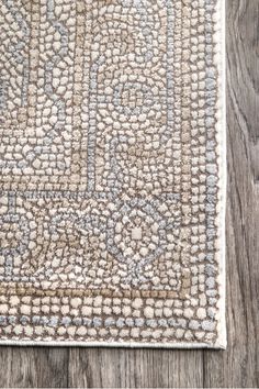 an area rug on the floor with wood floors in the background and a wooden floor