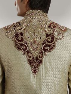 the back of a man's shirt with an intricate design on it, in gold and red