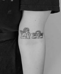 two cherubs tattoo on the left arm