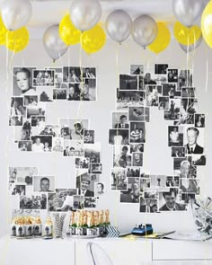 a party table with balloons and pictures on the wall above it, along with confetti