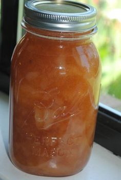 a jar filled with liquid sitting on top of a window sill next to a window