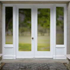 a white double door with glass and brick walkway