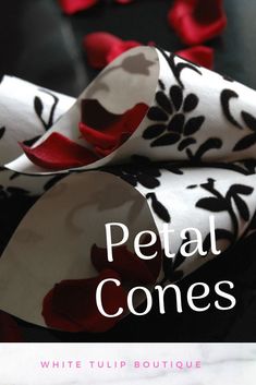 the cover of petal cones with red and black flowers on it, sitting on a table