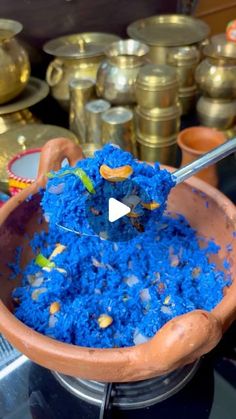 a bowl filled with blue food and a spoon sticking out of it's side