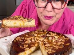 an older woman holding a piece of cake in front of her face