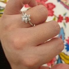 a woman's hand with a diamond ring on it