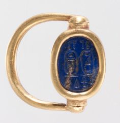 an ancient gold ring with a blue stone in the middle