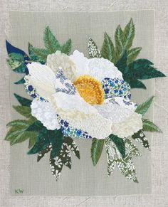 an embroidered white flower with green leaves on a gray background, surrounded by blue and white flowers