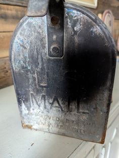 an old metal mailbox sitting on top of a white dresser