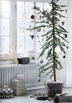 a small christmas tree in the corner of a room next to a radiator