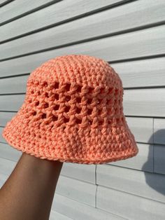 a hand is holding up a crocheted hat