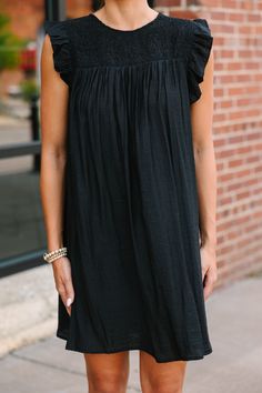 This black ruffled babydoll dress, with its ruffled cap sleeves and smocked neckline, is just the easy, breezy style you've been looking for! The fun ruffled detail adds a playful twist, while the babydoll fit keeps it laid-back and versatile. Perfect for a casual day out or a relaxed evening gathering, this dress is about to become your wardrobe's MVP. Round smocked neckline Button keyhole back Ruffled cap sleeves Babydoll cut No stretch Sydney is wearing the small. Longing For Love, Black Ruffled Dress, Breezy Style, Mint Julep Boutique, Ruffled Dress, Love Black, Easy Breezy, Model Fits, Black Ruffle