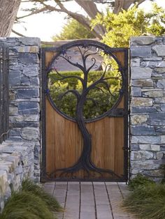 a wooden door with an iron tree design on the front entrance to a stone building