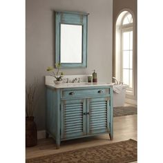 a bathroom with a sink, mirror and blue shuttered cabinet in the middle of it