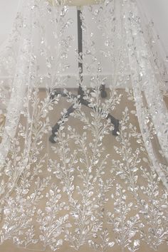 a white veil with flowers and leaves on it