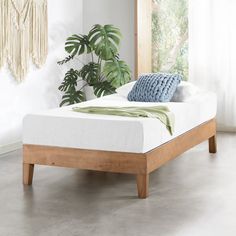 a bed with a wooden frame and white sheets