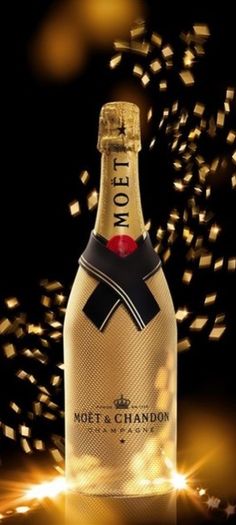 a bottle of champagne on a black background with gold confetti in the air