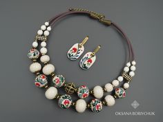 This exquisite jewelry set features handcrafted ceramic earrings and a matching necklace, adorned with original brass beads. Perfect for adding a touch of elegance and artistic flair to any outfit, this set is an ideal choice for holiday gifting. With its ethnic design and unique craftsmanship, it's a memorable gift for mom or any special woman in your life. 🔸 Material and Technique - Necklace - Handmade beads from white clay, coated with glaze and original painting, howlite, tinted hematite; author's bead and dividers - cast brass; bronze-colored findings. - Earrings - Handmade white clay beads, coated with glaze and original painting, tinted hematite, 18K gold-plated brass findings. 🔸 Size  Necklace size:  The circumference of the inner row of the choker is 40 cm (15.75 inch) The lengt Traditional Hand Painted Round Beads Jewelry, Bohemian White Hand Painted Necklace, Hand Painted Artisan Jewelry With Round Beads, Artisan Hand Painted Round Bead Jewelry, Traditional White Hand Painted Jewelry, Artist Jewelry, Jewelry Holiday, Ceramic Earrings, Brass Beads