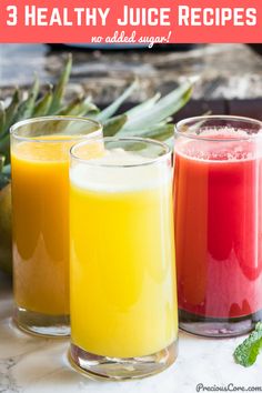 three glasses filled with juice sitting on top of a counter next to pineapples