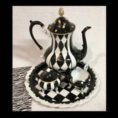 a black and white checkered tea set sitting on a plate with zebra print napkins