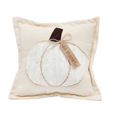 a white pumpkin pillow with a tag on it's front and the words, pumpkin co