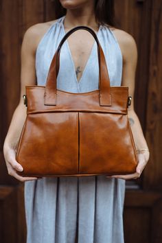 "This Brown cowhide leather bag is 100% handmade. this large tote bag is suitable for carrying everything in your everyday life. It has a Zipper Closure and Cross-Body strap. The bag has a cotton lining and it has 3 inner pockets. as you can see it made by really high-quality Italian leather.this leather calls \"Pelle Conciata Al Vegetale\", which means that the leather is tanned with only natural materials. Dimentions: - Width ( top of the bag ) : 32 Cm / 12.5'' ( Bottom of the bag ) : 37 Cm / Vegetable Tanned Leather Satchel For On-the-go, Brown Leather Bucket Bag With Top Carry Handle, Brown Leather Bucket Bag With Top Handle, Cognac Leather Shoulder Bag With Handle Drop, Brown Top Handle Shoulder Bag For Everyday, Brown Everyday Top Handle Shoulder Bag, Everyday Brown Top Handle Shoulder Bag, Classic Handheld Hobo Bag For Everyday Use, Vegetable Tanned Leather Bag For On-the-go